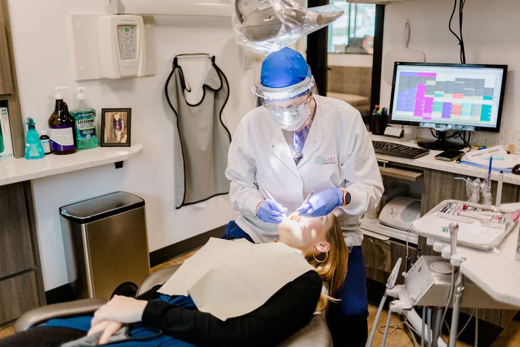 Dentist looking inside a patient's mouth with dental tools