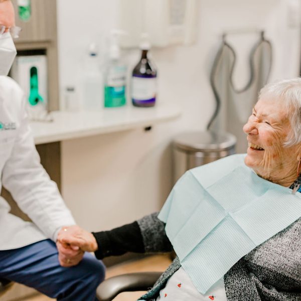 Happy older lady smiling with the dental implants dentist during an appointment